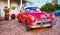 Red Classic Chevy is parked in front of a home