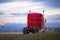 Red classic semi-truck with wooden staircase on scenic road