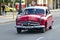Red classical taxi driving on La Habana