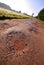 Red clay road with holes