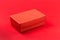 Red closed corrugated cardboard box on red