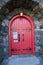 Red Closed door in a Strong Building constructed with strong stone wall