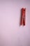 Red clothespin on pink background