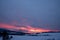 Red clouds at sunrise in winter  in the mountains with several houses in the valley, czech beskydy