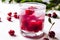 Red cocktail with cherry and ice on a white wooden background. Fresh summer cocktail with cherries and ice cubes