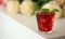 Red cocktail with ice, decorated with mint leaf on light background