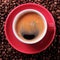 Red coffee cup black espresso roasted beans closeup top view
