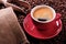 Red coffee cup with espresso froth and roasted beans