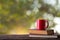 Red coffee cup placed on old wooden books background natural