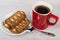 Red coffee cup, stuffed cookies in saucer and spoon