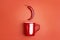 Red coffee mug with chili peppers on a red background. The concept of a hot drink