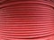 Red coiled electrical cable on the wooden spool