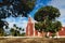 Red colonial church Itzimna in a park framed by trees, Merida, Yucatan, Mexico