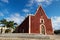 Red colonial church Itzimna in a park with palm trees, Merida, Yucatan, Mexico