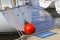 Red color fender hangs on the stern of a white white yacht. Blue