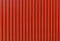 Red color straight line pattern texture. Bright red background with black strips.