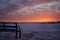 The red color of the sunset. Winter red sunset. Bench at sunset.