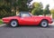 Red colored british six-cylinder sports car Triumph TR6