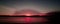 Red colored coastal sunrise seascape cloudscape.