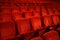 Red colored empty movie theater chairs in row