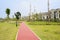 Red-colored path in grassy lawn along fenced houses