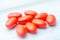 Red Colored Vitamins Pills on Wooden Background. Soft focused. Shallow depth of field