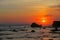 Red colors dramatic tropical sunset with black rocks silhouettes at Canggu beach, Bali, Indonesia