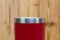 Red colour stainless steel tumbler or cold and hot storage cup on wood