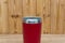 Red colour stainless steel tumbler or cold and hot storage cup on wood