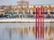 Red colour structure of four set of parallel poles erected in the centre of a lake. Season is Winter with lot of white snow.