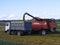 Red combine Emptying Graing into A Truck