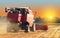 Red combine harvester soybean harvest against the backdrop of the sun in the sky. The farm operates in the field in the autumn sea