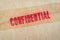 Red `Confidential` word printed on brown vintage envelope.