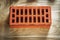 Red construction brick on wooden board bricklaying concept