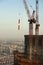 Red construction cranes against blue sky