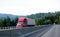 Red contemporary semi truck cargo reefer beside concrete fence d