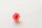 Red coronavirus ball on white flat surface