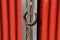 A red corrugated building is the backdrop for a rusty horse shoe attached to a rustic piece of wood