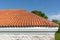 Red corrugated tile element of roof tile pattern over blue and cloudy spring sky day