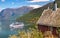 Red cottage against cruise ship in fjord, Flam, Norway