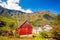 Red cottage against cruise ship in fjord, Flam, Norway