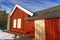 Red cottage with chimney on background of blue sky