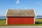 Red cottage at the seashore with the House Martins on the roof