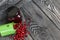 Red cranberries in an overturned green bucket. Lies on brushed boards. Next to it is cranberry jam in a jar