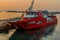 Red cruise ship moored at dock in seaport at sunset