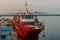 Red cruise ship moored at dock in seaport at sunset