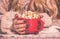 Red cup of appetizing golden popcorn in female hands. Female hands and cup of popcorn.