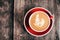 Red cup of cappucino with beautiful latte art