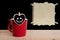 Red cup coffee with smile on heart board and brown paper with paper tape on chalkboard and wooden background.