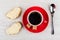Red cup with coffee, sugar, sandwiches with melted cheese, spoon